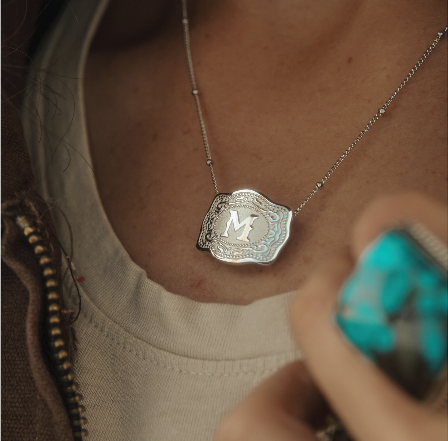 Woman wearing silver ultra mini belt buckle necklace with initial M - SpurWest western jewelry